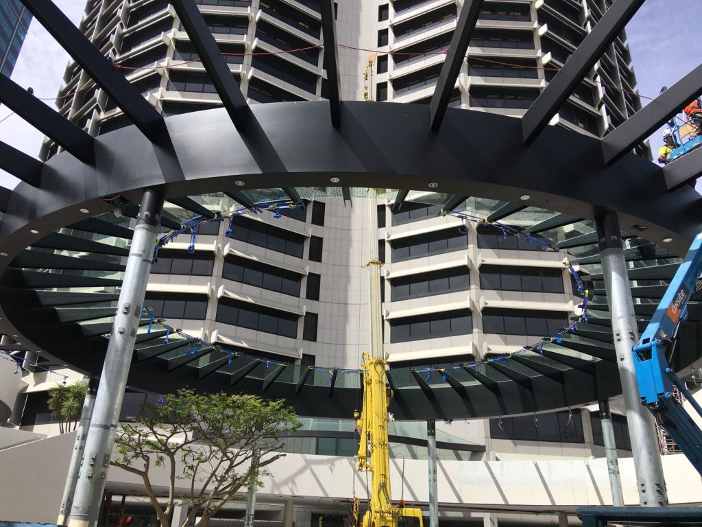 A large building featuring a prominent circular structure atop its design, showcasing modern architectural elements.